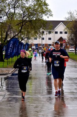 FARGO, NORTH DAKOTA-May 16, 2019 : Marathoners run in inclement weather at the annual Sanford Fargo Marathon which includes a cyclothon, dog race, youth, 5K, 10K, half, and full runs. clipart