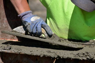 Beton işçisi malalar ıslak çamur (beton) yeni bir şantiye eteklerinde.
