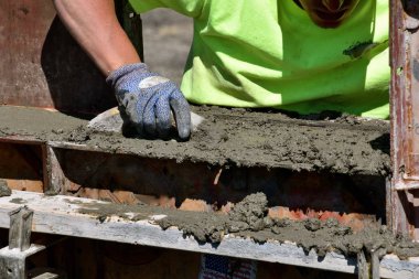 Beton işçisi malalar ıslak çamur (beton) yeni bir şantiye eteklerinde.