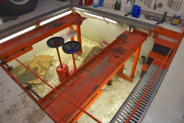 Mekanik bir aracın altında parçası üzerinde çalışabilir bir dolum istasyonunda bir çukur