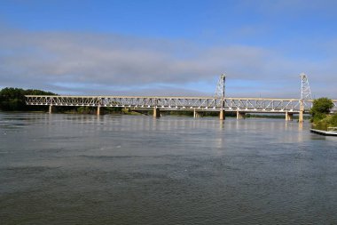 Bir şişmiş Missouri Nehri Yankton kenti tarafından Nebraska ve Güney Dakota bağlayan emekli iki katmanlı köprü altında akar. 