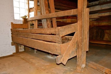 Ahırda hayvanları beslemek için kaba ahşaptan yapılmış eski bir saman yemliği temizlendi.