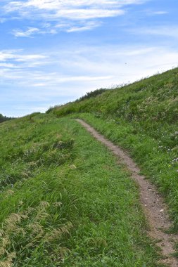 Yürürken bir patika tepeden çapraz olarak yukarı doğru dik açıyı azaltır.. 