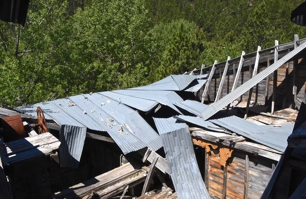 Crumbling building of a once covered  roof with sheet metal on an old mining structure