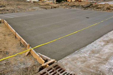 Yeni dökülmüş beton inşaat halindeki bir garaj yolunun ön kısmında iyileşiyor.. 