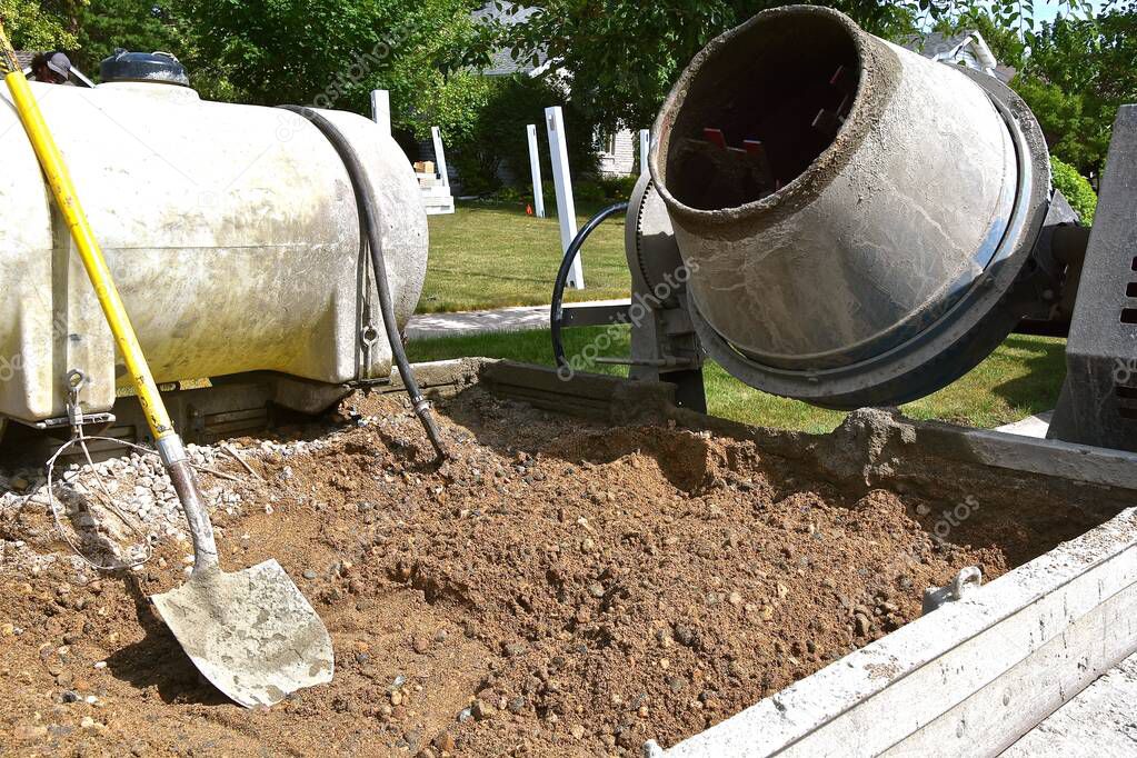 Portable cement mixer, water, sand, and materials in the back of  truck for concrete projects