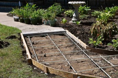Bir evin ön kapısına giden yol yeni bir beton parçasıyla onarılıyor.. 