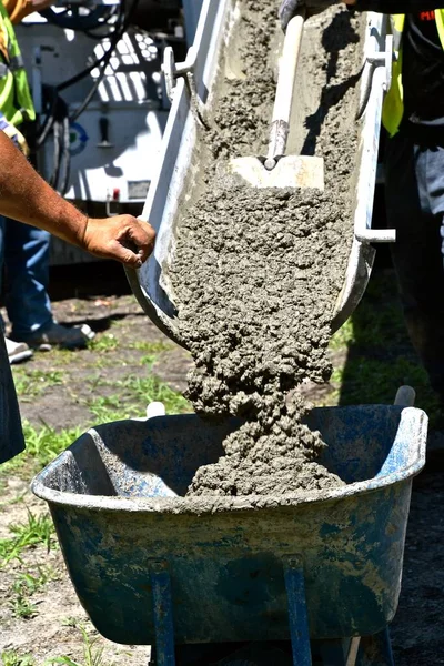 Concrete truck chute pouring wet cement Mix into metal bucket