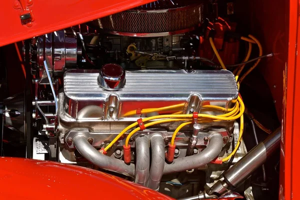 Klasik bir arabanın kaputu krom parçaları ve aksesuarlardan oluşan bir motoru ortaya çıkarır.. 