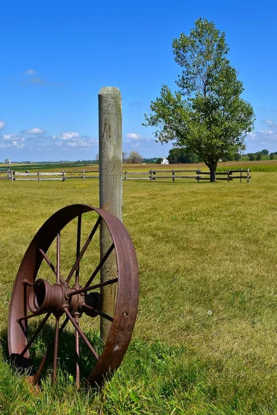 Old Steel Wheel Antique Machinery Leans Wooden Post Grassy Meadow — Stock Photo, Image