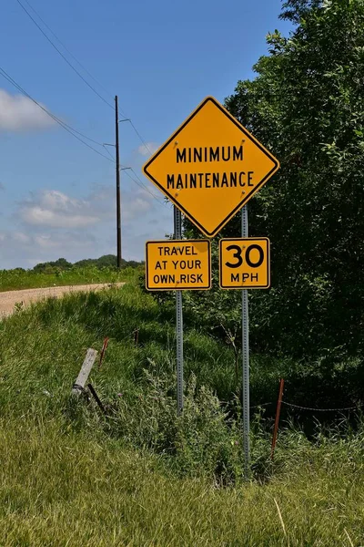 A rural minimum maintenance road posts a sign enforcing the speed limit at 30 mph.