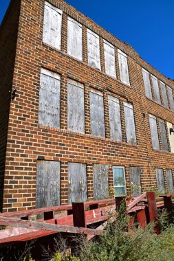 Pencereleri tahtayla kapatılmış eski bir tuğla okul binası harabeye döndü.. 