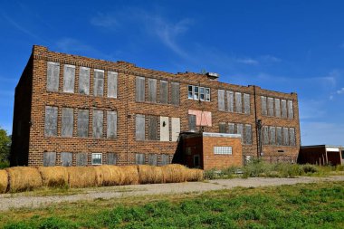 Pencereleri tahtayla kapatılmış eski bir tuğla okul binası harabeye döndü.. 