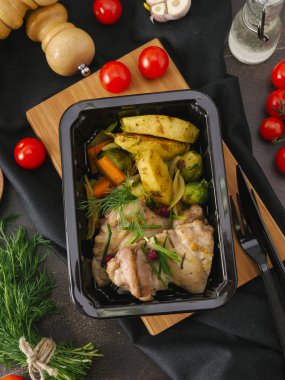 Siyah tepsisinde sebzeli ızgara tavuk fileto üstten görünüm ahşap tahta üzerinde