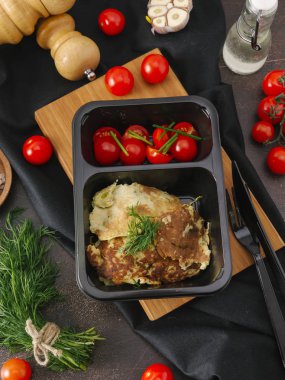 Ahşap tahta üzerinde siyah tepsisinde kiraz domatesli omlet closeup