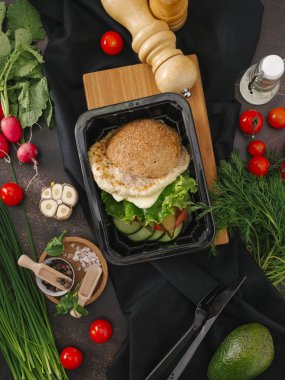 Tasty  burger with chicken and salad  in black tray  clipart