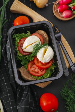 Sandviç domates, marul, dereotu ve siyah tepsisinde rafadan yumurta ile görünümü Kapat