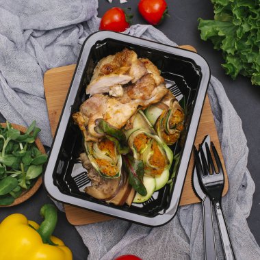 Dilimlenmiş armut soslu domuz eti pişmiş, kabak içinde siyah tepsi rulo