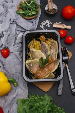 Sebze ve çatal bıçak takımı ile siyah tepsi Fırında Balık silmeleri üstten görünüm karanlık tablo