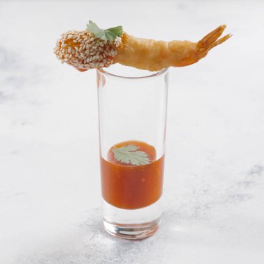 Susam ile derin yağda kızartılmış karides camına mermer yüzeyindeki sos ile servis