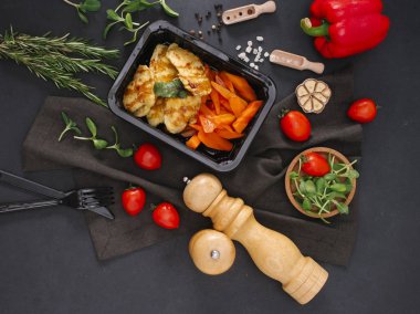 Siyah tepsisine dilimlenmiş kırmızı biber ile ızgara tavuk üstten görünüm