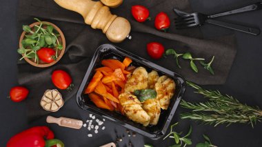 Siyah tepsisine dilimlenmiş kırmızı biber ile ızgara tavuk üstten görünüm