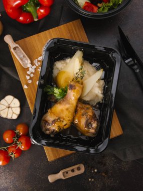 Fırında tavuk budu ile ahşap tahta üzerinde siyah tepsisinde servis patates püresi