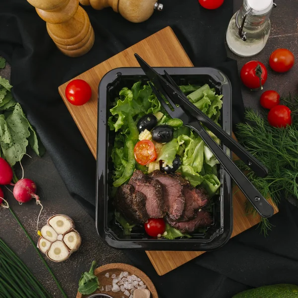 Et dilimleri sebze ile siyah tepsi içinde fırında