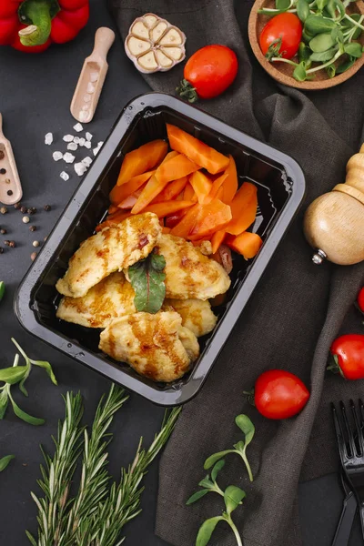 Taze havuç adet karanlık tablo üzerinde siyah tepsi üzerinde ızgara tavuk dilimleri