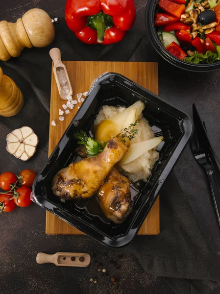 Fırında tavuk budu ile ahşap tahta üzerinde siyah tepsisinde servis patates püresi