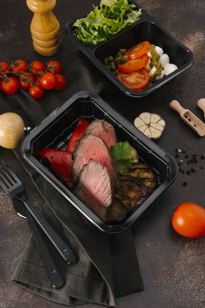 Bıçak ve çatal ile sığır eti dilimleri ile siyah kasetlerine Caprese salatası kavrulmuş