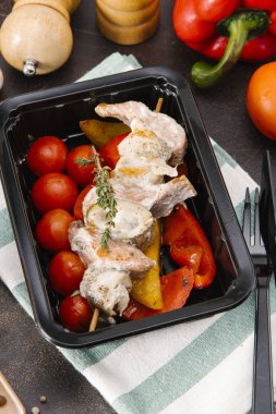 Somon ızgara domates ve biber bıçak ve çatal ile siyah tepsisinde