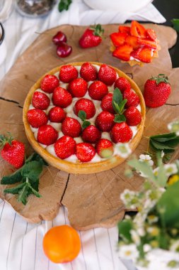 Çilekli pasta görünümü Kapat küçük Çilekli tart ve sawed ahşap tahta üzerinde çay ile servis