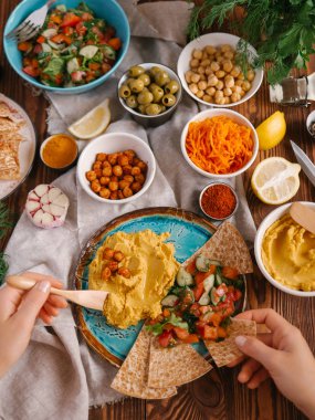 Üstten görünüm eller ve humus sebze ve Pide ile servis 