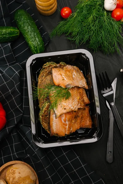 Roasted salmon fillet with corn cakes in plastic box