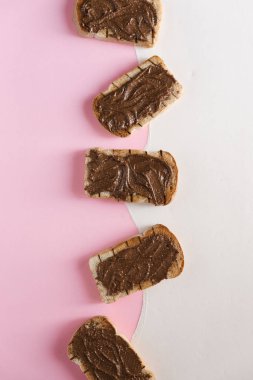 Çikolata tereyağlı tost üstten görünüm pembe ve beyaz arka plan üzerinde