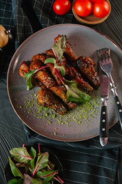 karamelize kaburga gri plaka üzerinde yeşil yaprakları ile servis