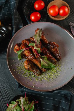 karamelize kaburga gri plaka üzerinde yeşil yaprakları ile servis
