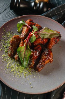 karamelize kaburga gri plaka üzerinde yeşil yaprakları ile servis