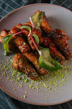 karamelize kaburga gri plaka üzerinde yeşil yaprakları ile servis