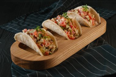 Ahşap tahta üzerinde guacamole soslu taze üç tacos 