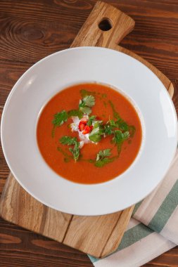 Ahşap masa üzerine maydanoz ile servis domates çorbası krem