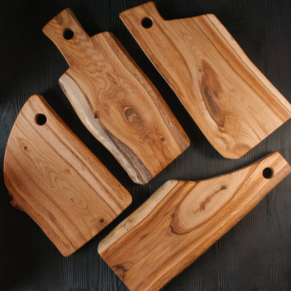 Wooden chopping boards on black wooden background