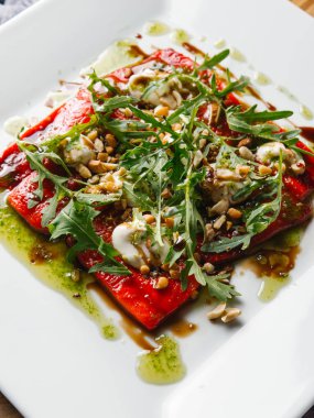 Izgara dolmalık biber, taze roka ve fındık beyaz tabakta sebze salatası