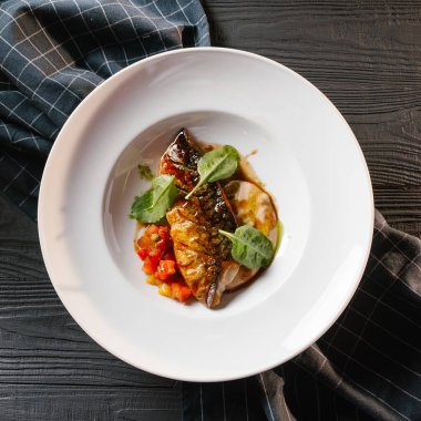 Kızarmış balık sosu ve beyaz tabakta sebze güveç ile servis