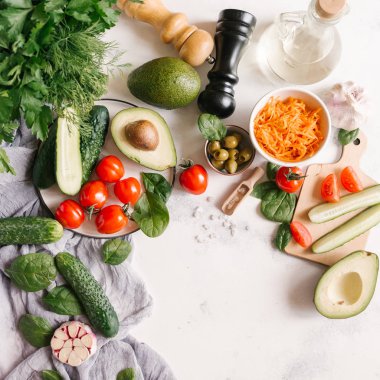 Beyaz beton zemin üzerinde sebze salatası için malzemelerin üstten görünüm 