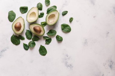 Yukarıdan kesilerek avokado Fesleğenli yeşil beyaz beton zemin üzerine bırakır
