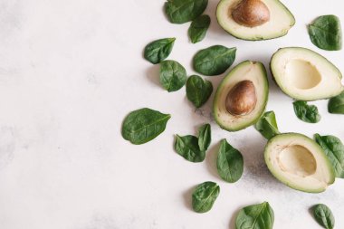 Yukarıdan kesilerek avokado Fesleğenli yeşil beyaz beton zemin üzerine bırakır