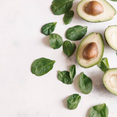 Yukarıdan kesilerek avokado Fesleğenli yeşil beyaz beton zemin üzerine bırakır