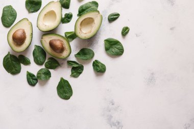 Yukarıdan kesilerek avokado Fesleğenli yeşil beyaz beton zemin üzerine bırakır